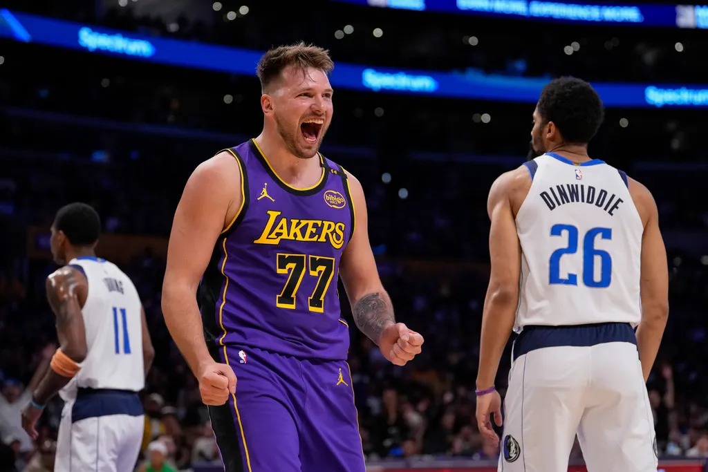 Los Angeles Lakers guard Luka Doncic (77) reacts next to Dallas Mavericks guard Spencer Dinwiddie (26) after scoring an drawing a foul during the first half of an NBA basketball game Tuesday, Feb. 25, 2025, in Los Angeles.